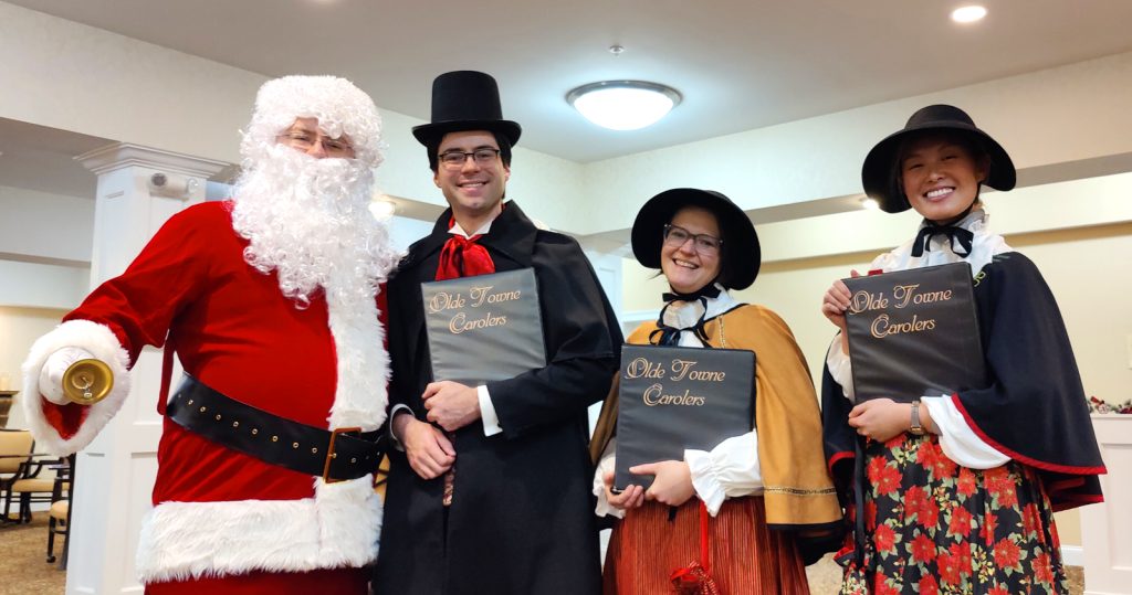 The carolers hang with Santa during an appearance in Groton, MA.