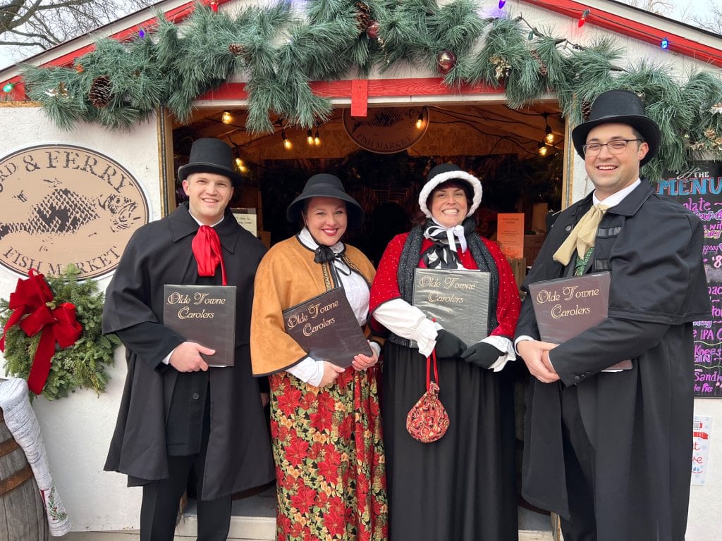 The carolers perform at the Easton Winter Village.