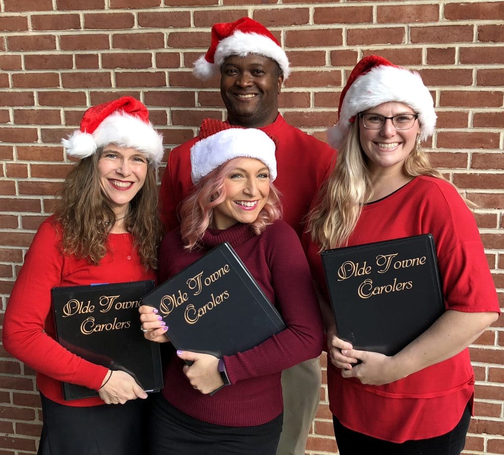 Our carolers show off the group's alternate look: red sweaters and Santa hats! Perfect for more casual events.